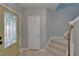 Open-concept entryway with tiled floors, staircase, and a bright yellow front door at 5914 Goldenbark Pl, Lithia, FL 33547