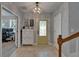 Bright foyer with decorative light fixture, yellow door, tiled floor, and functional shoe storage at 5914 Goldenbark Pl, Lithia, FL 33547