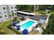 A community swimming pool area surrounded by lounge chairs, sun umbrellas and a privacy fence at 5920 80Th N St # 103, St Petersburg, FL 33709