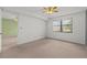 Spacious bedroom featuring neutral carpet, a ceiling fan, and natural light from the window at 5920 80Th N St # 103, St Petersburg, FL 33709