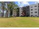 View of condo building with private screened patios surrounded by green space at 5920 80Th N St # 103, St Petersburg, FL 33709