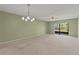Spacious living room with neutral carpet and sliding glass doors to a screened-in patio at 5920 80Th N St # 103, St Petersburg, FL 33709