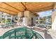 An outdoor kitchen and dining area with an installed grill, picnic tables and ceiling fans at 5920 80Th N St # 103, St Petersburg, FL 33709