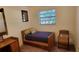 Cozy bedroom with a twin bed, small desk, chair, and natural light from the window at 5967 Terrace Park N Dr # 101, St Petersburg, FL 33709