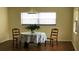 Charming dining area featuring hardwood floors, a round table, and bright natural light from a large window at 5967 Terrace Park N Dr # 101, St Petersburg, FL 33709