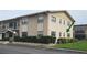 Two-story condo unit featuring neutral siding and a well-manicured hedge at 5967 Terrace Park N Dr # 101, St Petersburg, FL 33709