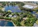 Stunning aerial view of the property nestled amidst lush trees and sparkling lake, offering serene and picturesque living at 6501 Barcellona Rd, Land O Lakes, FL 34637