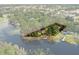 Aerial view showcasing the property's boundaries along the waterfront, with mature trees and a private dock at 6501 Barcellona Rd, Land O Lakes, FL 34637