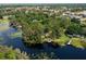 Aerial view of the property featuring waterfront access, mature trees, and a tranquil lakeside setting at 6501 Barcellona Rd, Land O Lakes, FL 34637
