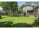 View of the home's backyard with well-maintained lawn, screened-in porch, and access to a dock at 6501 Barcellona Rd, Land O Lakes, FL 34637