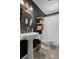 This bathroom has a pedestal sink, gold finishes, dark gray walls and a white shower curtain at 6501 Barcellona Rd, Land O Lakes, FL 34637