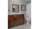 This bathroom features a wood vanity, white countertop and white tiled floors at 6501 Barcellona Rd, Land O Lakes, FL 34637