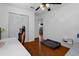 This bedroom has wood floors, a bed and a ceiling fan at 6501 Barcellona Rd, Land O Lakes, FL 34637
