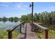 Picturesque wooden dock on a serene lake with calm water and lush greenery, ideal for relaxation and outdoor enjoyment at 6501 Barcellona Rd, Land O Lakes, FL 34637