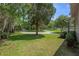 Expansive front yard with mature trees, circular driveway, and lush green lawn, offering a picturesque setting at 6501 Barcellona Rd, Land O Lakes, FL 34637