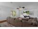 Bright living room with a ceiling fan, large sectional sofa and doors leading to a screened patio with scenic views at 6501 Barcellona Rd, Land O Lakes, FL 34637