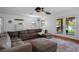 This open living room includes a ceiling fan, large sectional sofa, hardwood flooring, and access to a scenic screened patio at 6501 Barcellona Rd, Land O Lakes, FL 34637
