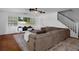 This spacious living room features hardwood floors, a ceiling fan, large sectional sofa and staircase at 6501 Barcellona Rd, Land O Lakes, FL 34637