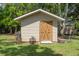 Charming outdoor shed with double wooden doors and decorative flowerpots, adding character to the property at 6501 Barcellona Rd, Land O Lakes, FL 34637