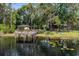 Scenic waterfront property featuring a private dock, storage shed, and tranquil views of the lake at 6501 Barcellona Rd, Land O Lakes, FL 34637