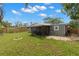 A wide view of the backyard with a new fence, manicured lawn, and screened patio at 6620 Del Prado Ter, New Port Richey, FL 34652