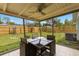 Cozy screened patio features outdoor dining set and ceiling fan overlooking the fenced backyard at 6620 Del Prado Ter, New Port Richey, FL 34652