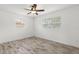 Bright bedroom features wood-look flooring, ceiling fan, and two windows for lots of natural light at 6620 Del Prado Ter, New Port Richey, FL 34652