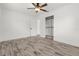 Bedroom features wood-look flooring, ceiling fan, closet, and adjacent door at 6620 Del Prado Ter, New Port Richey, FL 34652