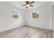 This bedroom features wood-look flooring, a ceiling fan, and two windows for lots of light at 6620 Del Prado Ter, New Port Richey, FL 34652