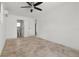 Bedroom features tile flooring, a ceiling fan, and an adjacent bathroom at 6620 Del Prado Ter, New Port Richey, FL 34652