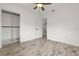 This bedroom features wood-look flooring, a ceiling fan, closet, and adjacent door at 6620 Del Prado Ter, New Port Richey, FL 34652