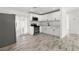 Modern kitchen featuring white cabinets, stainless steel appliances, and wood-look tile flooring at 6620 Del Prado Ter, New Port Richey, FL 34652