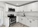 Bright kitchen with stainless steel appliances, white cabinets, and stylish countertops at 6620 Del Prado Ter, New Port Richey, FL 34652