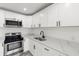 Well-appointed kitchen with white cabinetry, modern appliances, and elegant countertops at 6620 Del Prado Ter, New Port Richey, FL 34652