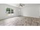 Bright living room featuring wood-look tile flooring and a large picture window at 6620 Del Prado Ter, New Port Richey, FL 34652
