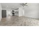 Bright, open-concept living area with wood-look tile flooring and stainless steel appliances at 6620 Del Prado Ter, New Port Richey, FL 34652