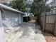 Spacious backyard showcasing concrete driveway, wooden fence, and mature trees at 6710 Hibiscus S Ave, South Pasadena, FL 33707