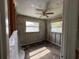 Bedroom awaiting refurbishment, featuring a ceiling fan, natural light, and block-wall construction at 6710 Hibiscus S Ave, South Pasadena, FL 33707