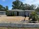 Charming single-story gray home featuring a low concrete fence and xeriscaped yard, offering low maintenance appeal at 6710 Hibiscus S Ave, South Pasadena, FL 33707
