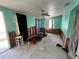 Spacious living room awaiting renovation, featuring teal walls and ample natural light from the windows at 6710 Hibiscus S Ave, South Pasadena, FL 33707