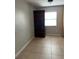 Small, tiled bedroom with storage hutch and window at 7210 N Manhattan Ave # 1311, Tampa, FL 33614