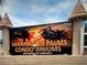 Entrance sign for Manhattan Palms Condominiums with palm tree imagery and decorative brick pillars at 7210 N Manhattan Ave # 1311, Tampa, FL 33614
