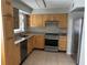 Well-lit kitchen features stainless steel appliances and natural wood cabinetry at 7210 N Manhattan Ave # 1311, Tampa, FL 33614