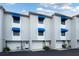 Charming townhome exterior with blue awnings, white trim and welcoming front entrances at 745 Pinellas Bayway S # 206, St Petersburg, FL 33715