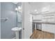 Updated bathroom features a pedestal sink next to a kitchen with stainless steel appliances at 7627 Deleon Ct, Tampa, FL 33615