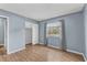Bedroom features sleek wood floors, a closet, and a bright window dressed with neutral curtains at 7627 Deleon Ct, Tampa, FL 33615