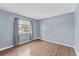 Bedroom featuring sleek wood floors and a bright window dressed with neutral curtains at 7627 Deleon Ct, Tampa, FL 33615
