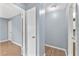 Upstairs hallway featuring neutral paint, laminate flooring, and access to various rooms at 7627 Deleon Ct, Tampa, FL 33615