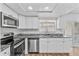 Modern kitchen features stainless steel appliances, granite countertops, and white cabinets at 7627 Deleon Ct, Tampa, FL 33615