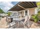 Back patio featuring pavers, outdoor seating, a table with chairs, and a retractable awning at 7851 120Th St, Seminole, FL 33772